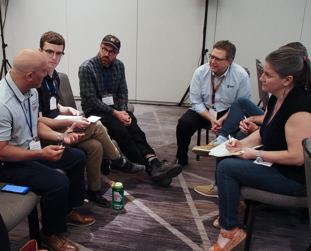 a group of people talking and taking notes