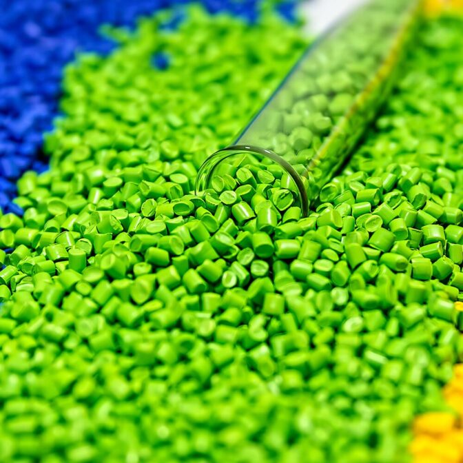 vial of blue, green and yellow pellets spilling onto a white surface