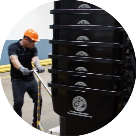 A man moving recycling bins