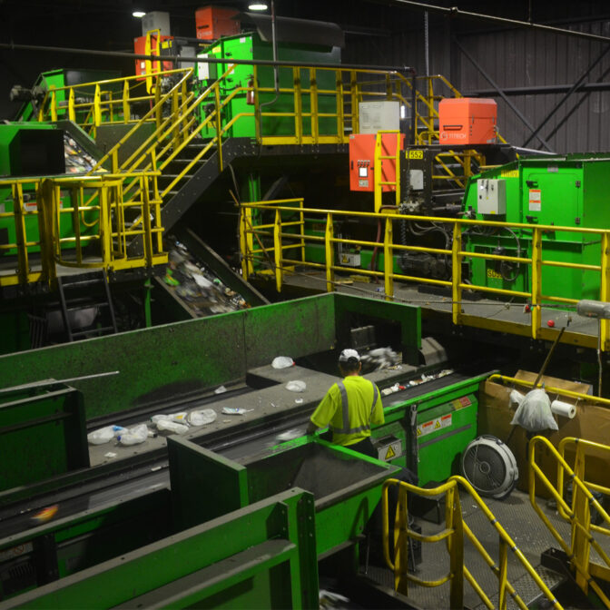 photo of a person working at a machine in a recycling facility