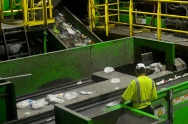 photo of a person working at a machine in a recycling facility