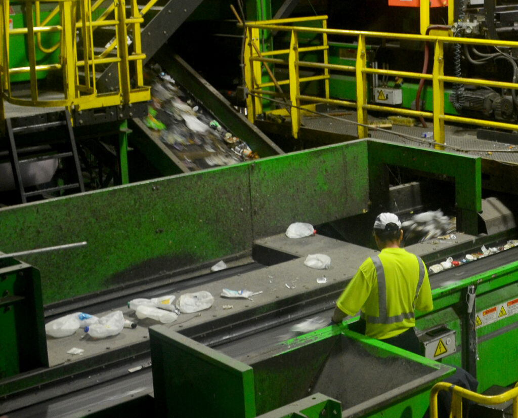 photo of a person working at a machine in a recycling facility