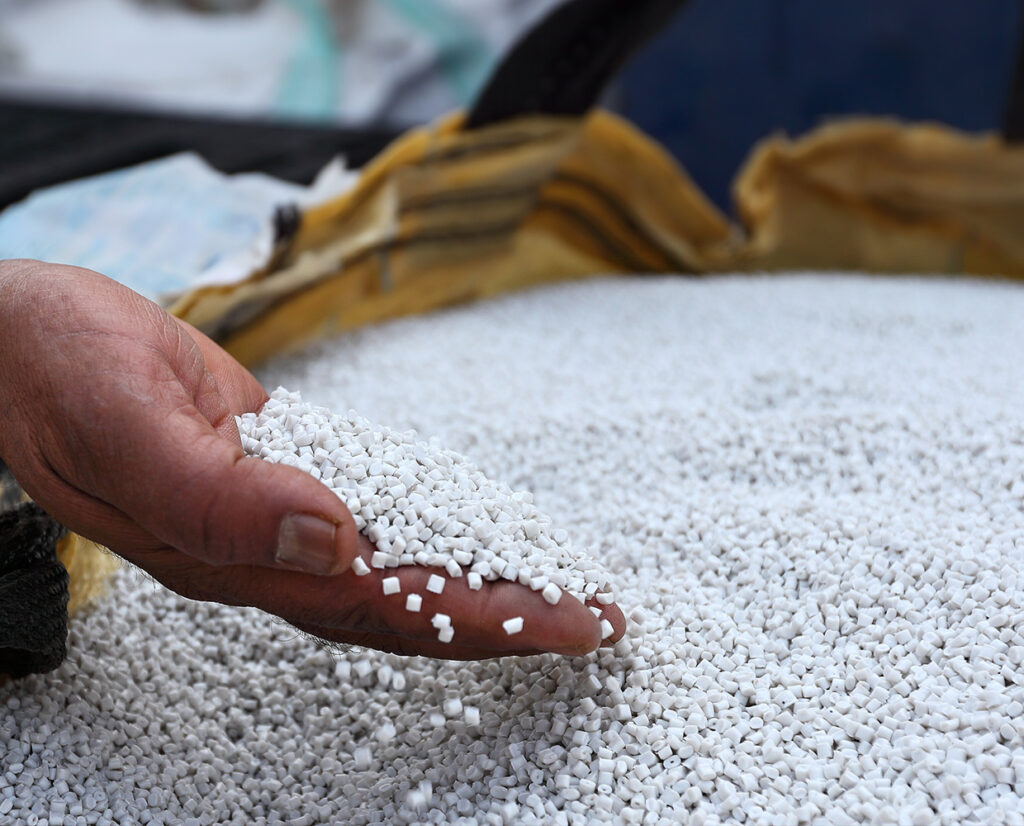 a hand holding white pellets