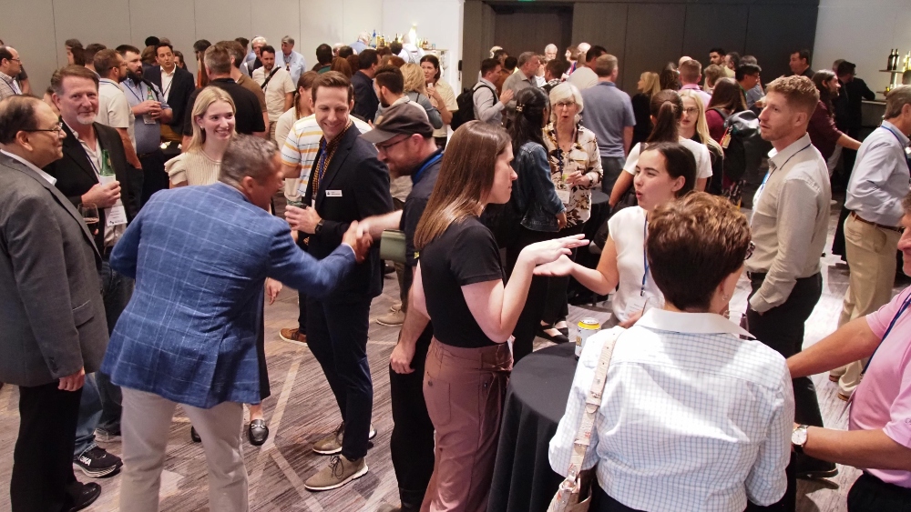 A crowd of people networking at a reception