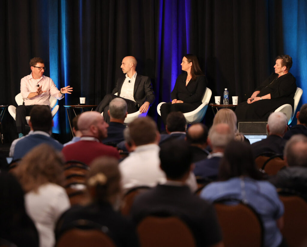 photo of a panel of four people talking at a conference